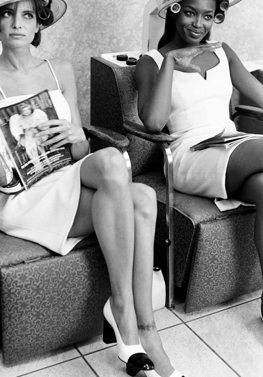 Elegant black and white portrait of two women sitting in vintage hair salon chairs, showcasing Pamela Hanson’s classic fashion photography style with emphasis on beauty, fashion, and timeless elegance.