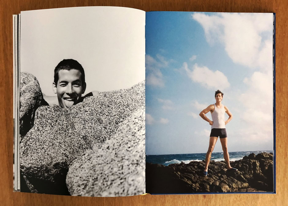 Vibrant beach photoshoot featuring a young man posing on rocks under a bright blue sky, capturing stunning outdoor portrait photography with natural lighting and scenic coastal background.