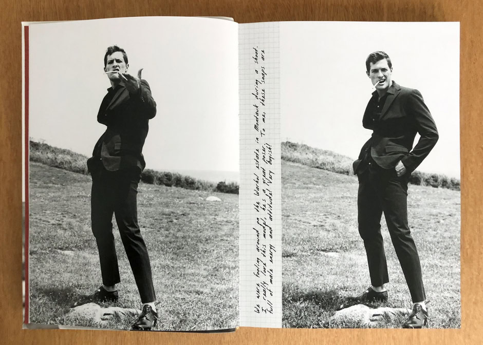 Man in black suit standing outdoors on grassy field black and white photograph.
