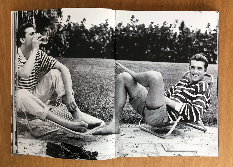 Relaxed young men lounging outdoors in vintage striped shirts, enjoying drinks and sunshine, photographed in black and white for a timeless, stylish summer lifestyle scene.