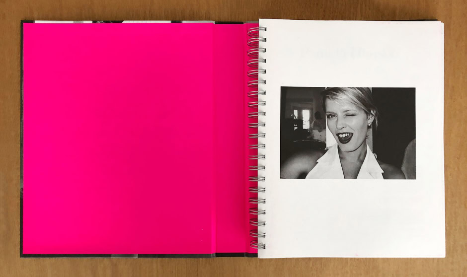 Vibrant pink interior page with black and white portrait shot of a woman winking and smiling, showcasing Pamela Hanson’s expert photography, capturing expressive and stylish portrait images.