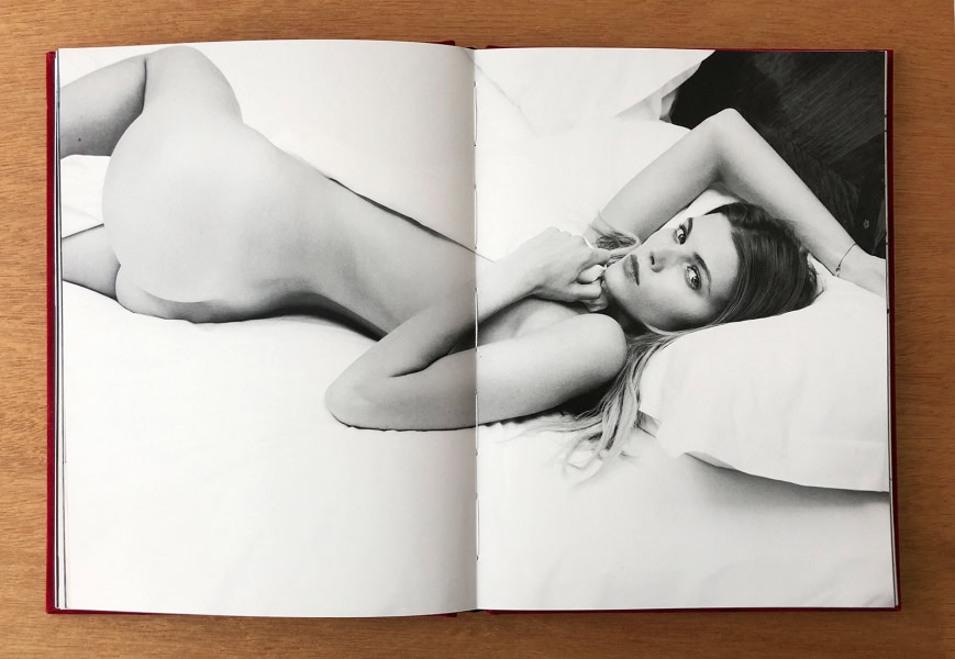 Elegant black and white portrait of a nude woman lying on a bed, captured by Pamela Hanson Photography, showcasing timeless beauty and artistic photography.