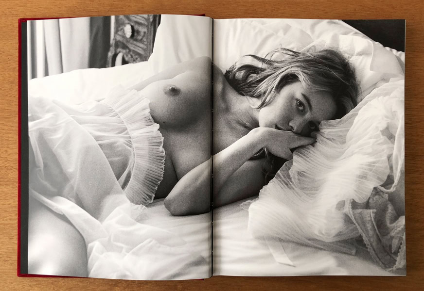 Sensual black and white portrait of a woman lying on bed, emphasizing elegance, beauty, and fine art photography, by Pamela Hanson.