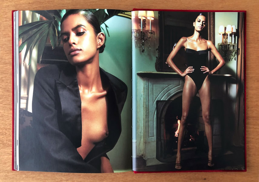 Elegant portrait of a woman in a sophisticated black outfit, emphasizing high-end fashion photography, with luxurious indoor setting and warm lighting.