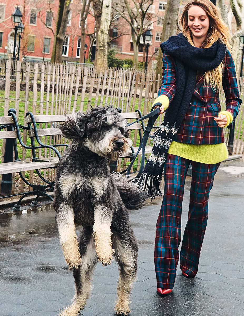 Vibrant portrait of a woman walking a black and gray mixed breed dog in an urban park, highlighting lifestyle and pet photography, with colorful fall backdrop.