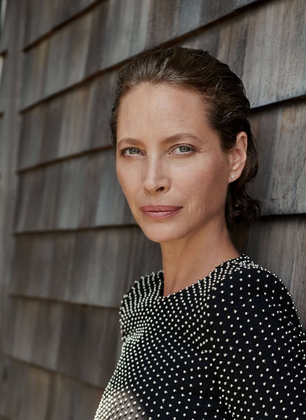 Elegant portrait of a woman with short brown hair against a wooden wall, showcasing professional fashion photography by Pamela Hanson.