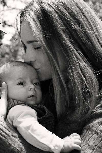 Soft black and white portrait of a woman tenderly kissing a baby, showcasing family love and maternal bond, captured by Pamela Hanson Photography, emphasizing emotional authenticity and fine art portraiture.