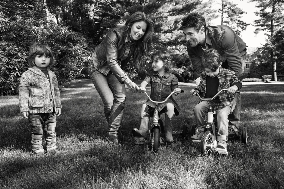Happy family outdoor portrait, children riding bikes with parents in a park, black and white photography, joyful family moments, lifestyle photography for family and kids, Pamela Hanson Photography.