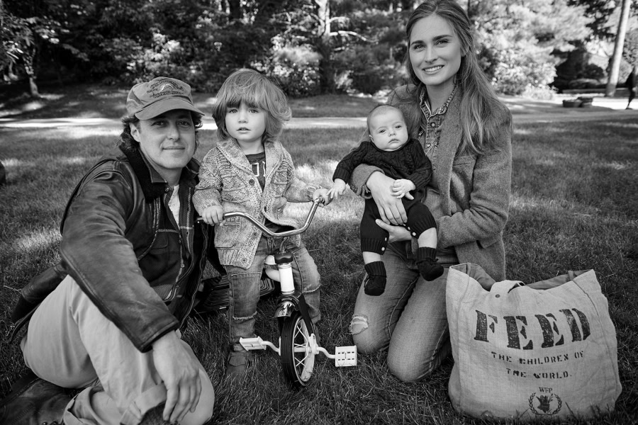 Family portrait of parents and two young children outdoors in black and white, captured with professional photography for timeless family memories.