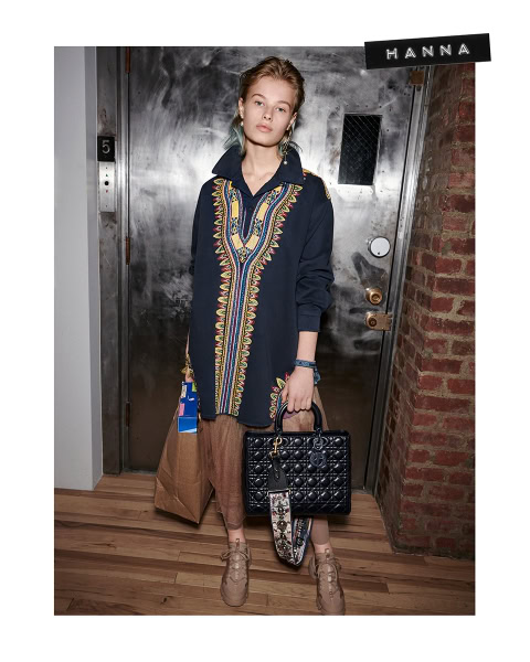 Vibrant designer embroidery coat styled with beige casual pants, accessories, and handbags at urban apartment entrance.