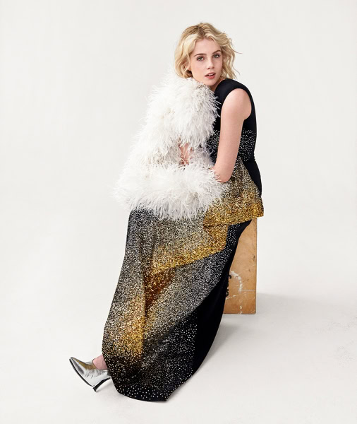 Bright blonde female model wearing glamorous black and gold sequin evening gown with feathered white shawl, fashion photography by Pamela Hanson.