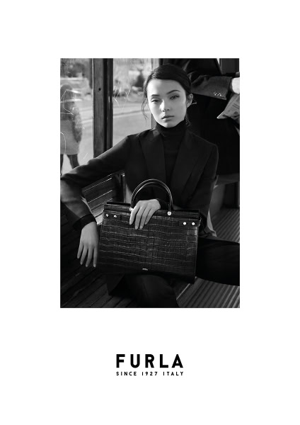 Elegant black and white portrait of a woman holding a designer Furla handbag, showcasing luxury fashion photography by Pamela Hanson.