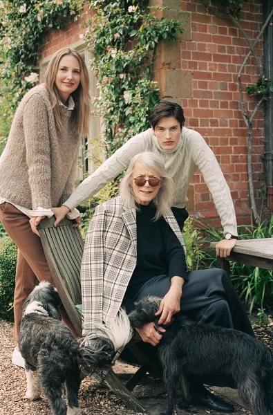 Elegant family portrait capturing three women and two dogs in a lush garden setting, showcasing Pamela Hanson photography's focus on natural light, candid moments, and contemporary lifestyle images.