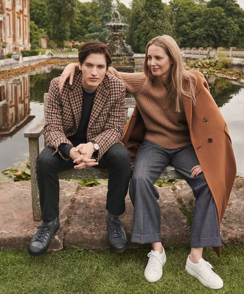 Beautiful women and young man sitting on park bench near pond in elegant fall fashion, outdoor portrait, Pamela Hanson Photography, high-end fashion and lifestyle photography, classic and modern style.