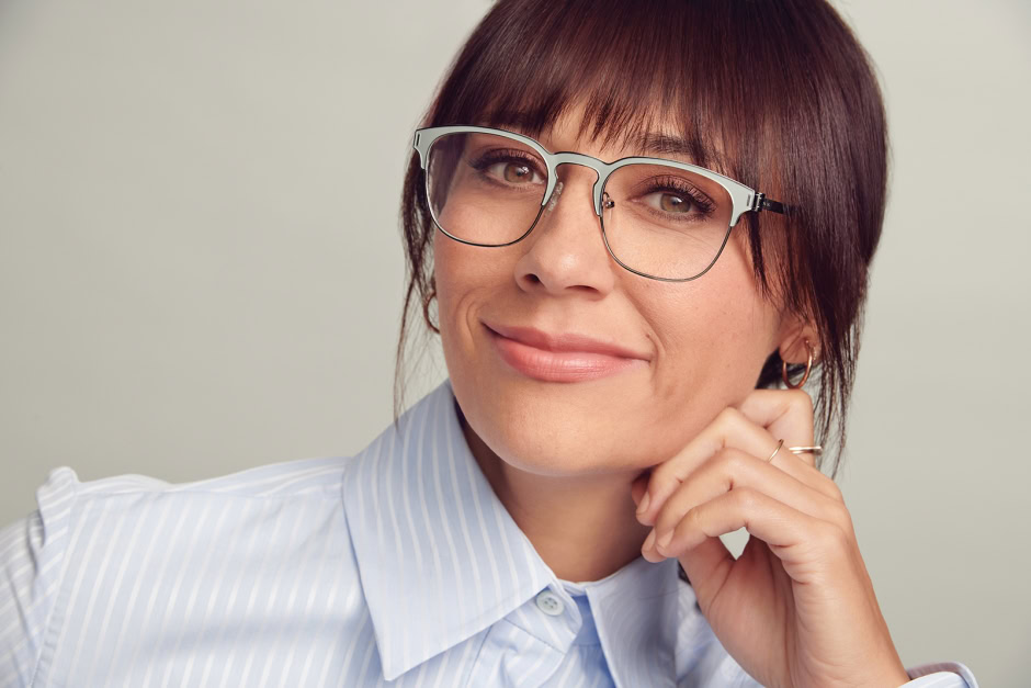 High-quality portrait of a confident woman with short brunette hair and eyeglasses, showcasing professional editorial photography on Pamela Hanson Photography website.