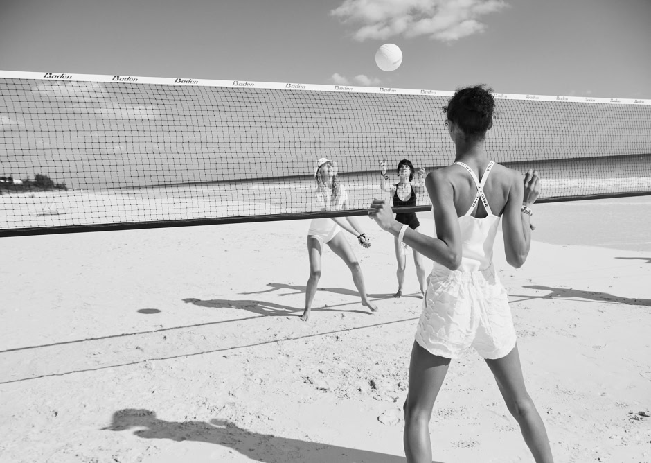 Cute women playing beach volleyball on sand, black and white photography, capturing athleticism and summer fun, shot by Pamela Hanson Photography.