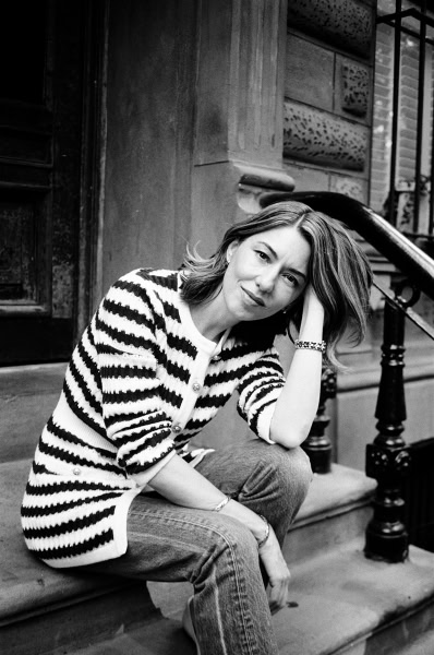 Elegant black and white portrait of a woman sitting on a stoop, showcasing Pamela Hanson’s artistic photography style and focus on candid, sophisticated portraiture.