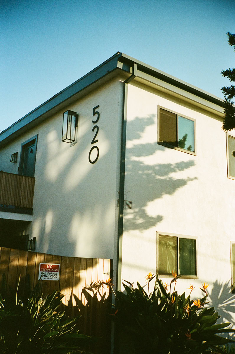 Modern white residential building with large windows and ambient shadows, captured in natural daylight - a classic example of contemporary architecture photography.