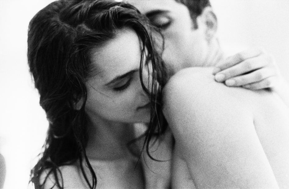 Elegant black and white portrait of a woman with wet hair embracing a man, capturing intimate and sensual moments with artistic photography.