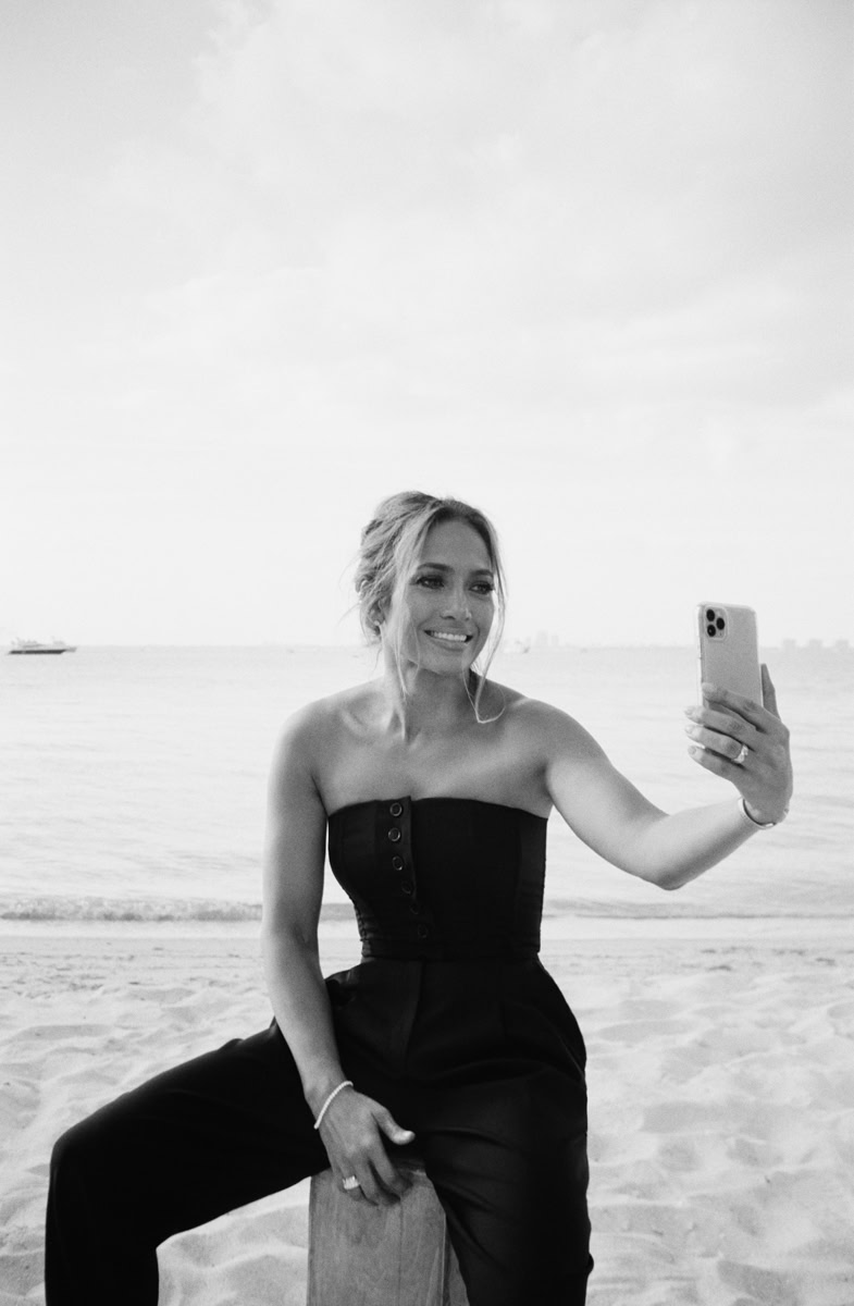 Elegant woman taking a selfie on the beach in black and white, showcasing fashionable photography and portrait style by Pamela Hanson Photography.