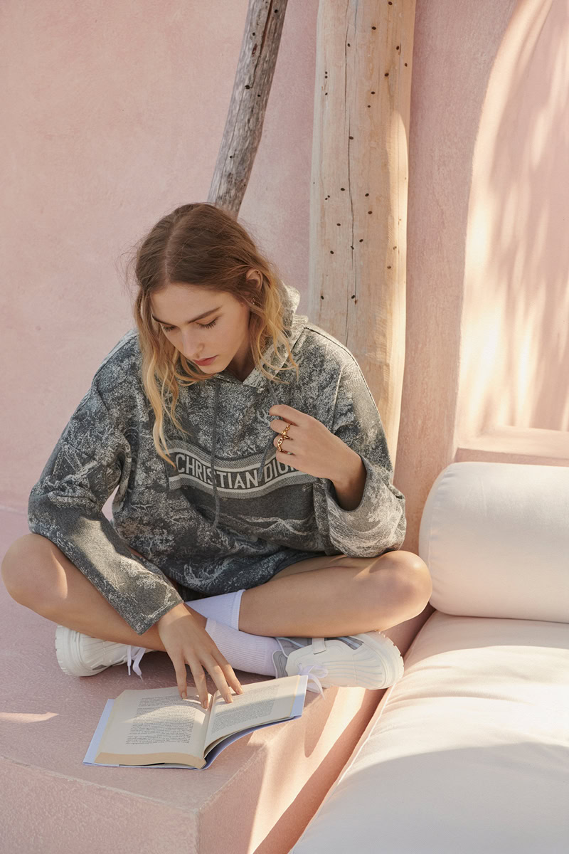 Soft natural lighting captures a young woman reading a book in a modern, minimalist setting showcasing Pamela Hanson Photography's lifestyle and fashion portrait photography.