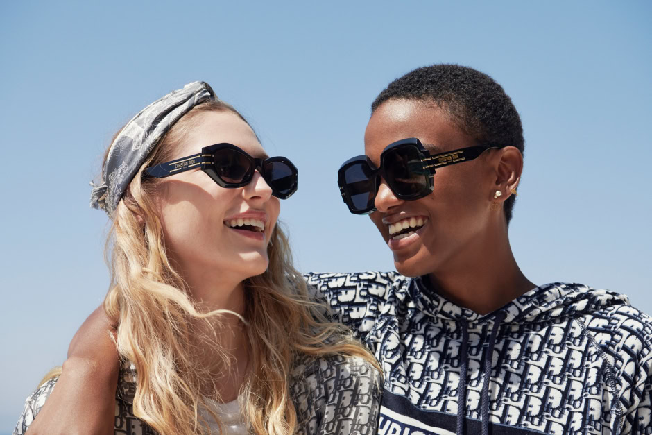 Fashion photography featuring two women wearing luxury designer sunglasses, bright sunny day, close-up shot, stylish outdoor accessories, high fashion lifestyle, Pamela Hanson Photography.