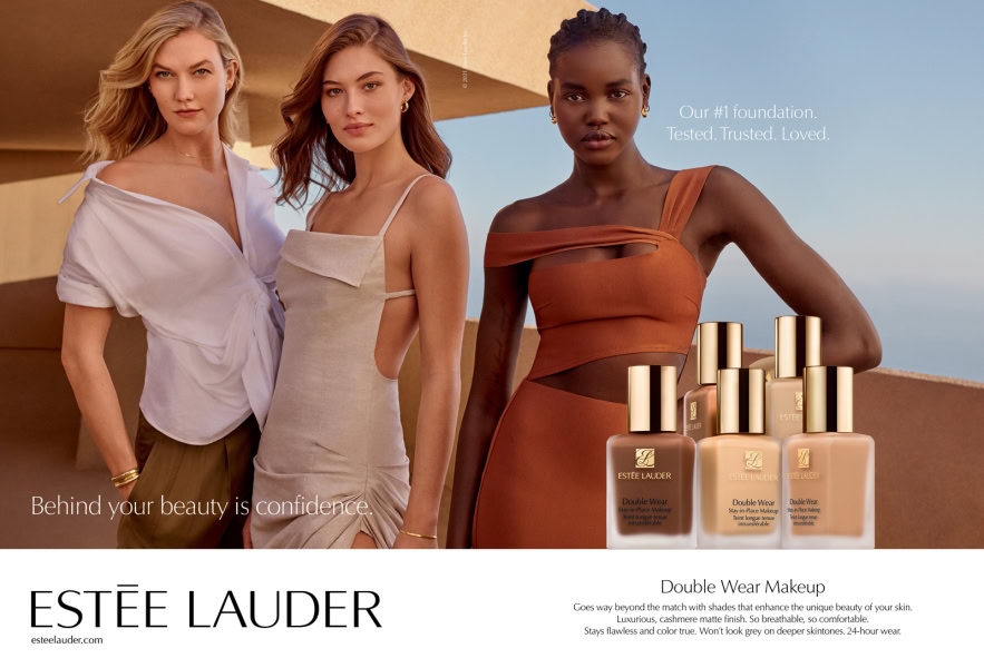 Soft-lit fashion portrait featuring three diverse women showcasing confident beauty and showcasing Estée Lauder Double Wear makeup bottles for an inclusive, elegant skincare ad.