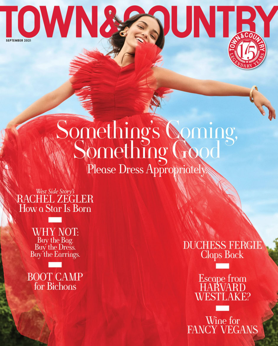Luxury fashion portrait of a smiling woman in a flowing red dress outdoors, high fashion photography, vibrant colors, elegant styling, sophisticated mood, professional model shoot, magazine cover, celebrity fashion model, couture gown, glamorous event, editorial style, upscale fashion photography, editorial fashion photoshoot, high-end fashion imagery, prestigious magazine cover, refined clothing design, striking visual presentation, outdoor fashion photo session, elegant red dress outdoor shoot, stylish women fashion photography.