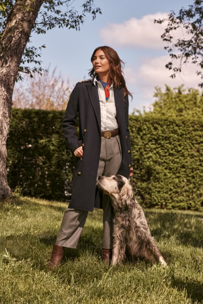 Elegant woman with dog outdoor fashion portrait by Pamela Hanson Photography, showcasing luxury lifestyle photography, stylish clothing, and outdoor setting.