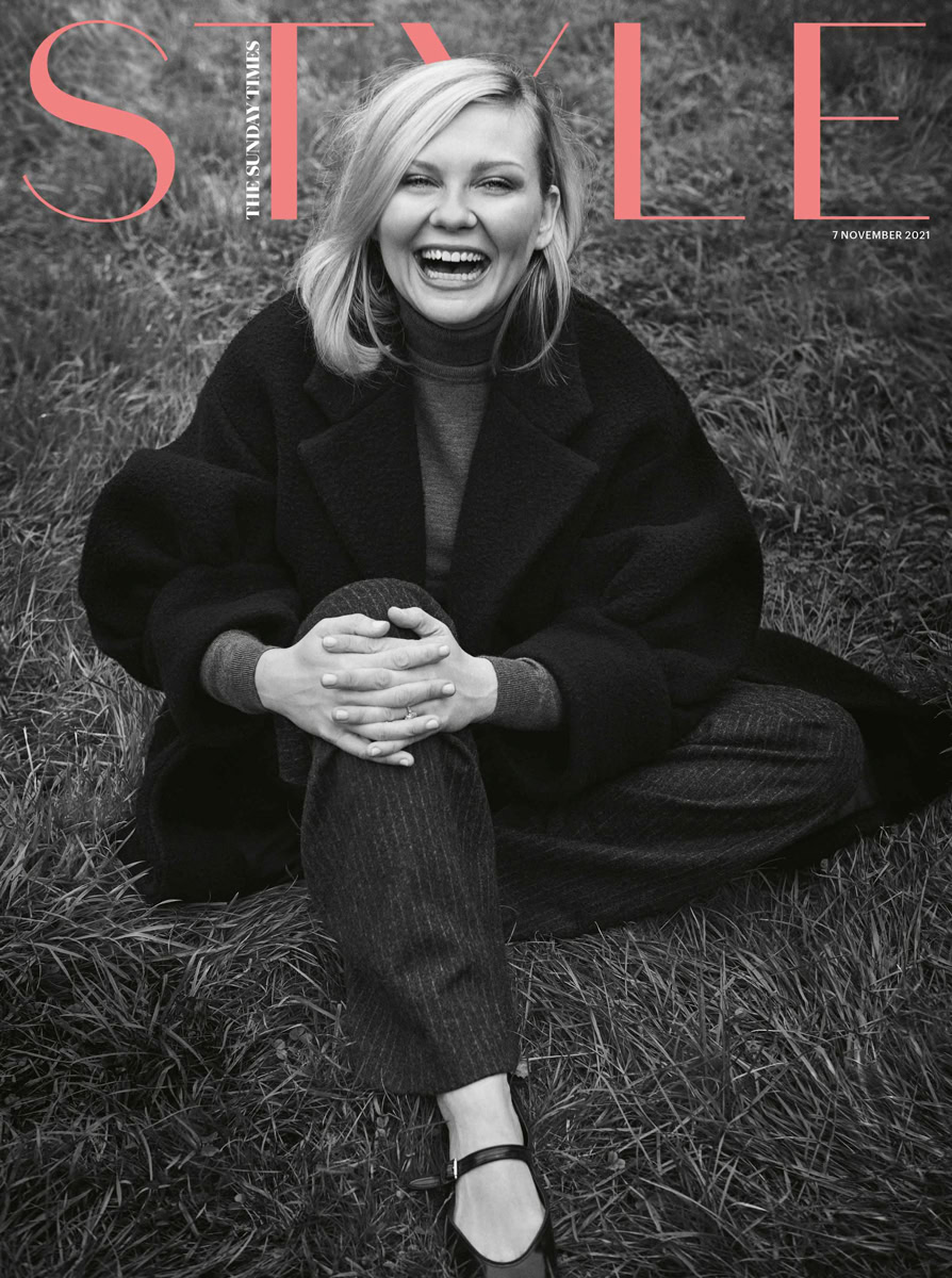 Vibrant portrait of a smiling woman sitting on grass, captured by Pamela Hanson Photography, showcasing professional black and white fashion and lifestyle photography.