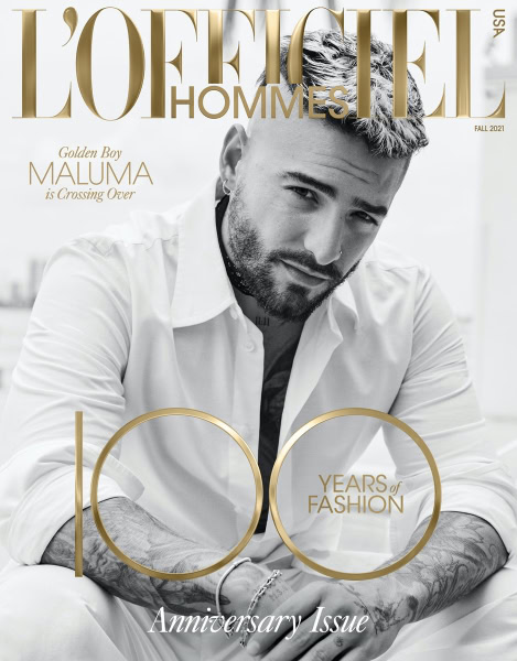 Elegant black and white portrait of a stylish man with tattoos on his arms, featuring sophisticated lighting and fashion-forward styling for editorial photography.
