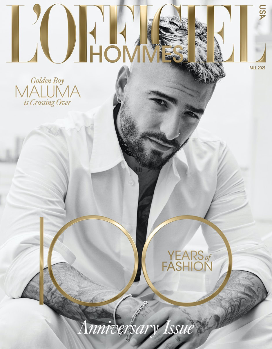 Elegant black and white portrait of a stylish man with tattoos on his arms, featuring sophisticated lighting and fashion-forward styling for editorial photography.