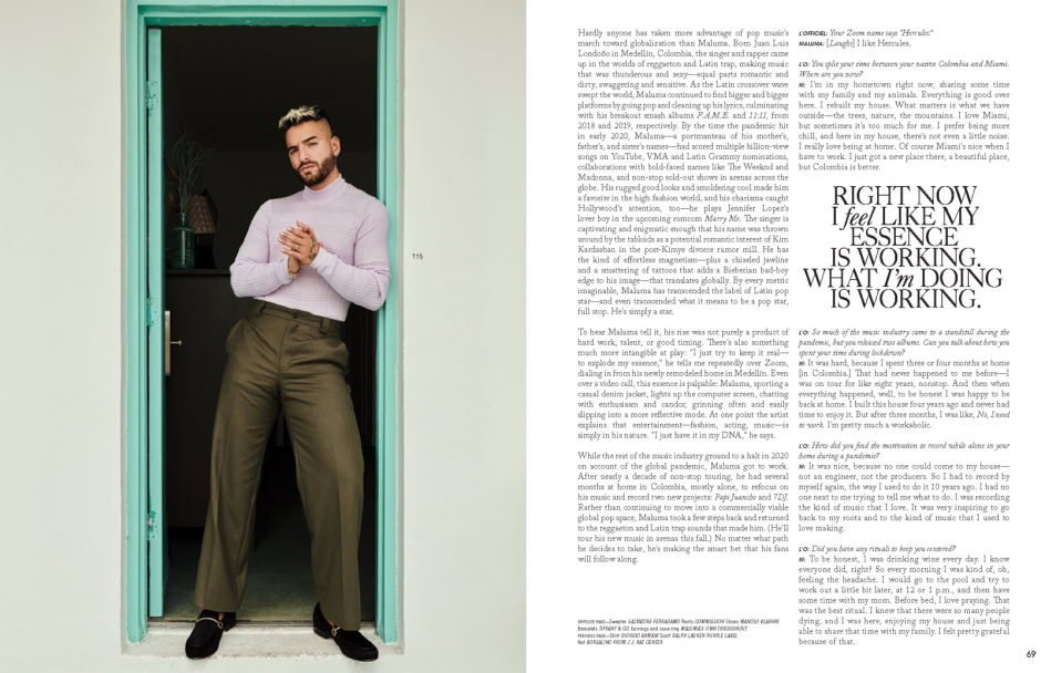 Portrait of a male model standing in a teal doorframe, wearing a lavender sweater and olive green trousers, showcasing lifestyle and fashion photography for Pamela Hanson Photography.