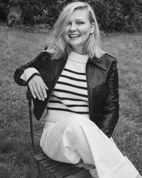 Elegant black and white portrait of a smiling woman outdoors, showcasing professional portrait photography by Pamela Hanson, featuring natural expressions and stylish casual attire.