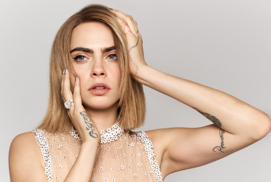Vibrant portrait of a woman with blonde hair, blue eyes, and tattoos, showcasing modern fashion and beauty photography by Pamela Hanson.