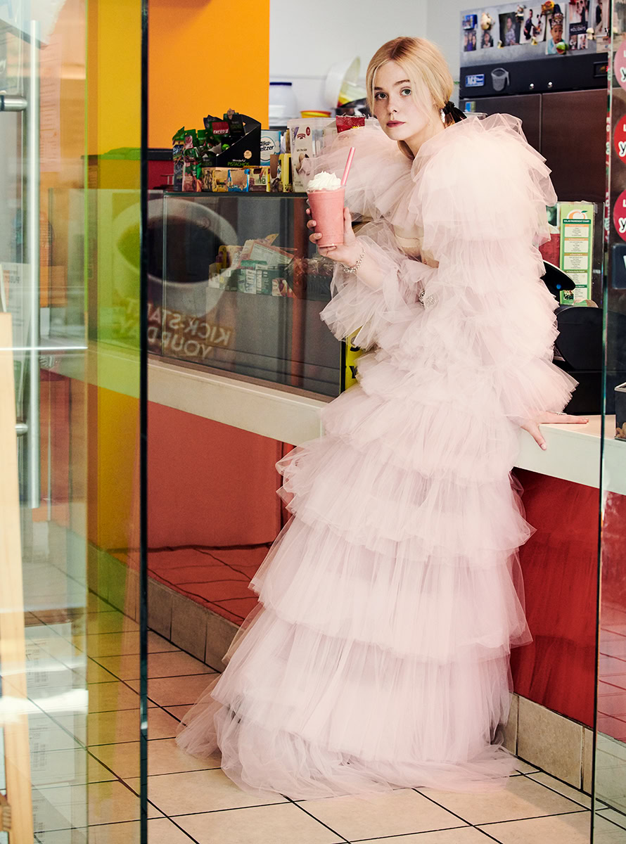 Pink tulle gown woman holding milkshake in fast food restaurant image.