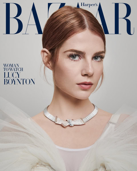 Luxury fashion portrait of a young woman with red hair wearing a glamorous diamond necklace on Harper's Bazaar cover.