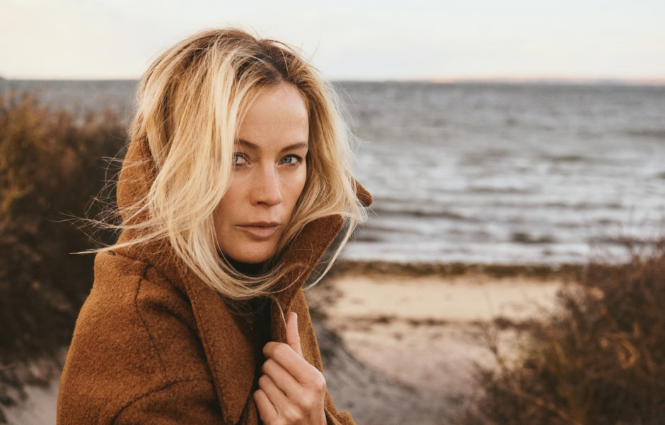 Elegant woman portrait on the beach during sunset, showcasing professional fashion photography by Pamela Hanson.
