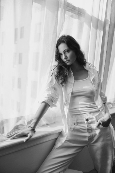 Elegant black and white portrait of a woman by Pamela Hanson Photography, featuring natural light, soft curtains, and classic fashion style.