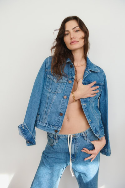 A woman in a denim jacket and jeans, posing in a minimalist studio setting for Pamela Hanson Fashion Photography.