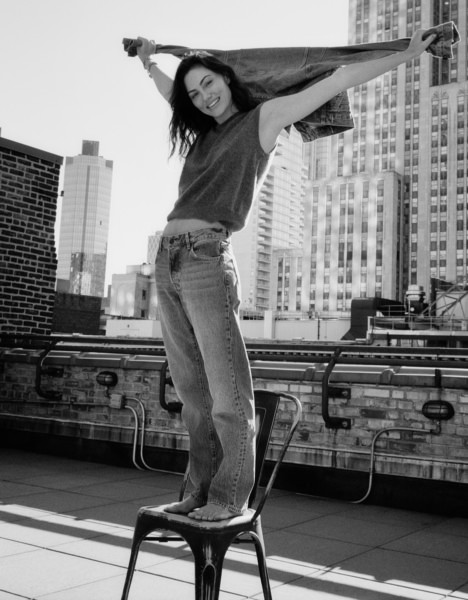 Girl balancing on a chair on rooftop in cityscape, black and white photo, fashion portrait by Pamela Hanson Photography.