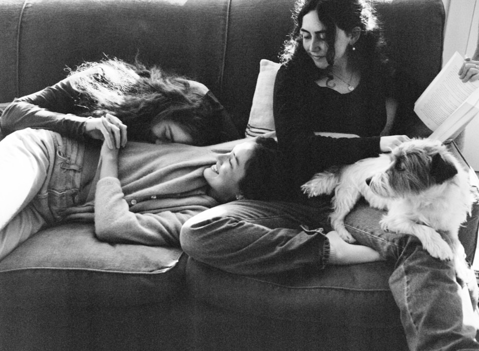 Relaxed women lounging with dogs in a cozy home setting, capturing candid moments, lifestyle photography, emotional connection, and pet companionship.