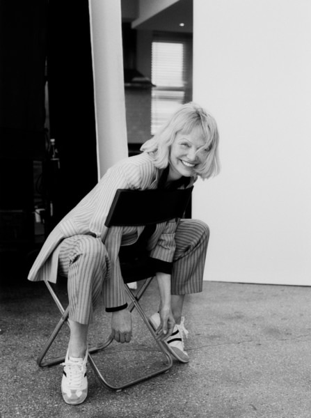Portrait of a smiling woman in a contemporary photoshoot, featuring casual fashion and relaxed pose, captured by Pamela Hanson Photography.
