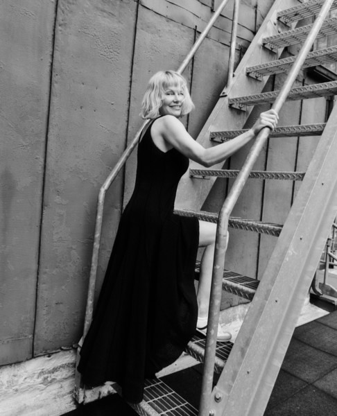 Street style black and white portrait of mature woman in elegant long dress on metal staircase, urban fashion photography, timeless beauty, confident pose, Pamela Hanson Photography.