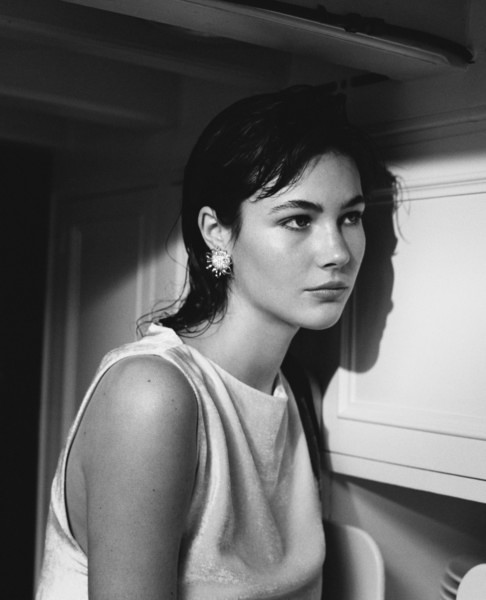 Elegant black and white portrait of a woman with short dark hair and striking earrings, showcasing Pamela Hanson’s artistic fashion photography style, emphasizing beauty and sophistication.