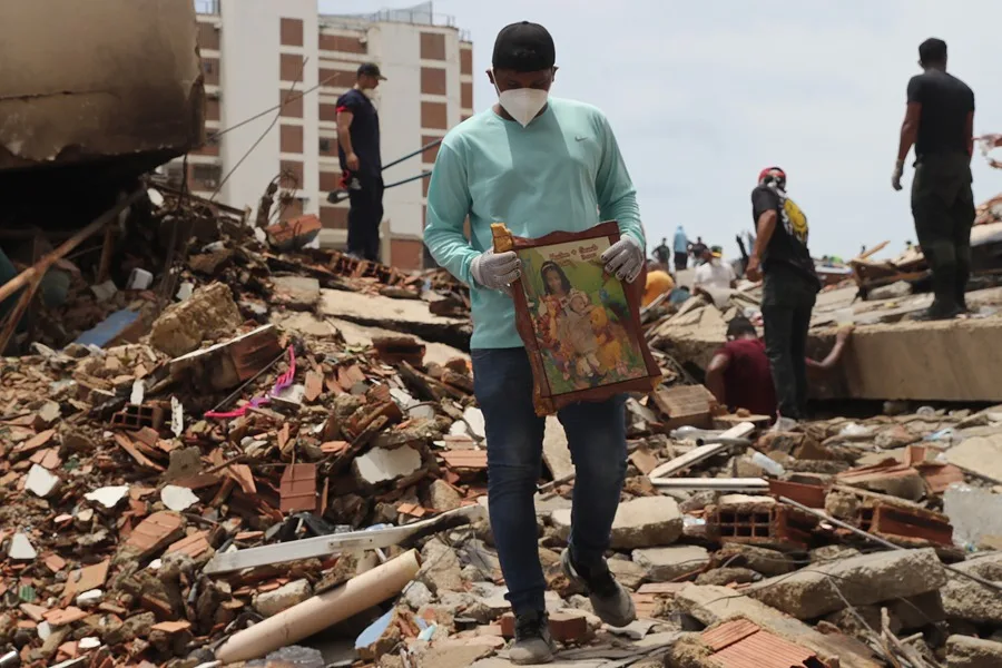 Un hombre sostiene un cuadro sobre escombros de edificaciones destruidas este martes, en La Guaira (Venezuela)