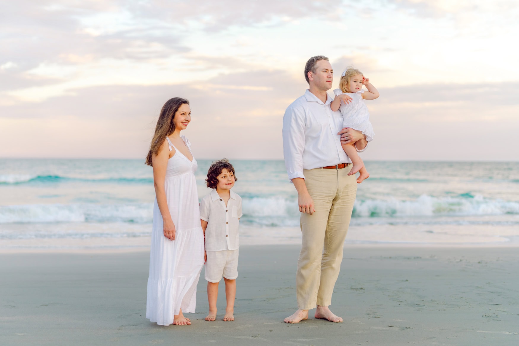 Family beach portrait in Myrtle Beach featuring parents and children walking along the shoreline at sunset