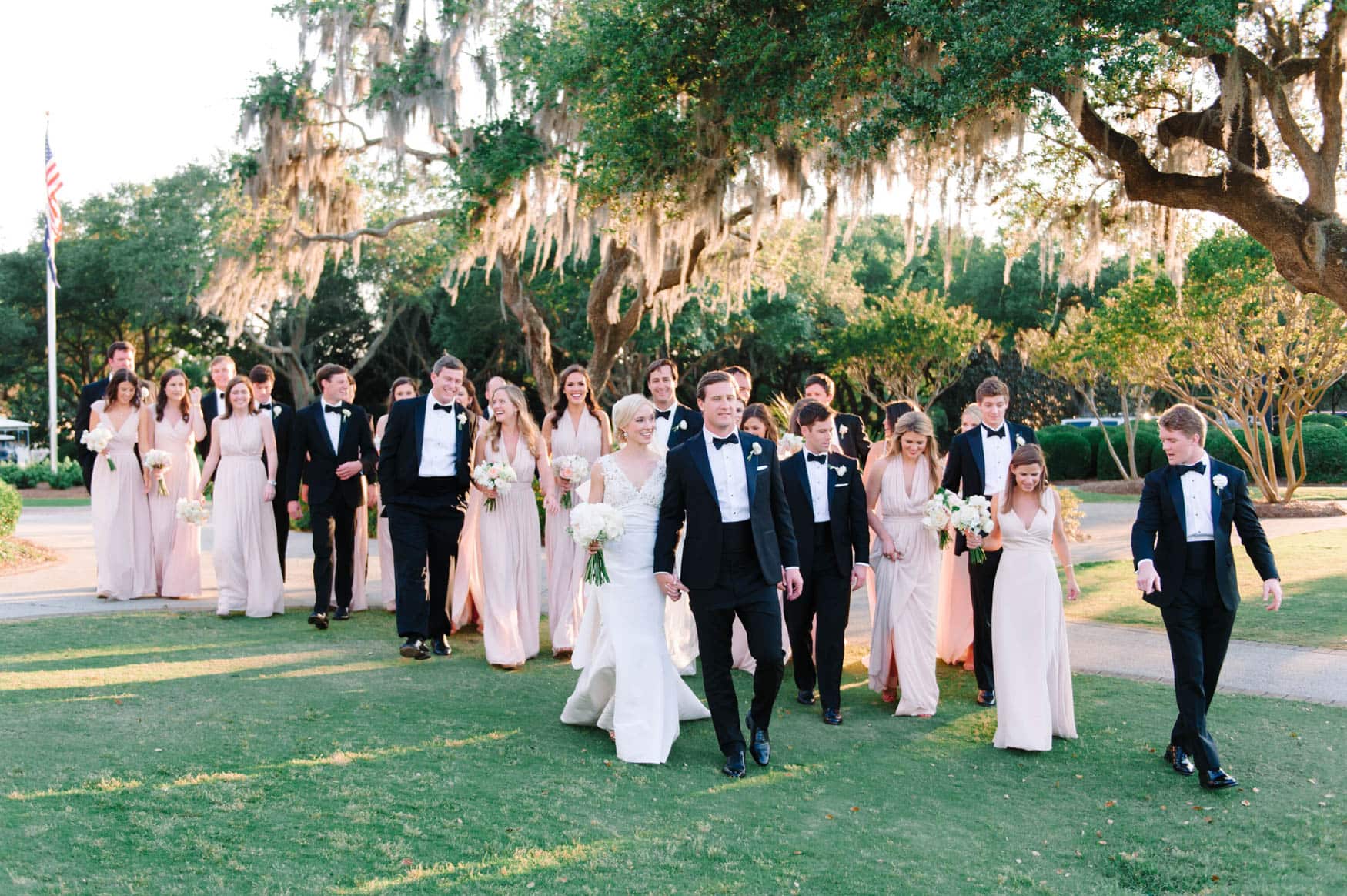 Myrtle Beach wedding party walking under oak trees with Spanish moss at an elegant outdoor ceremony