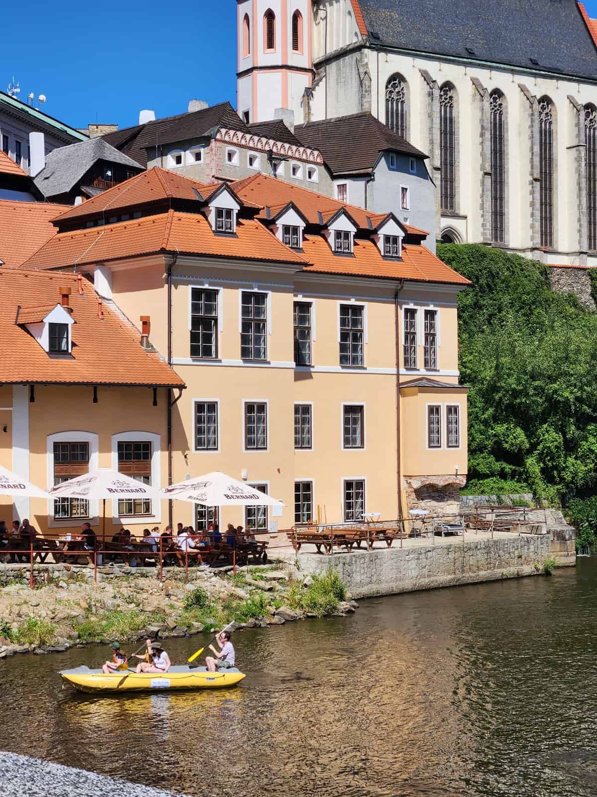 buildings with orange rooftops, people kayaking in Cesky Krumlov