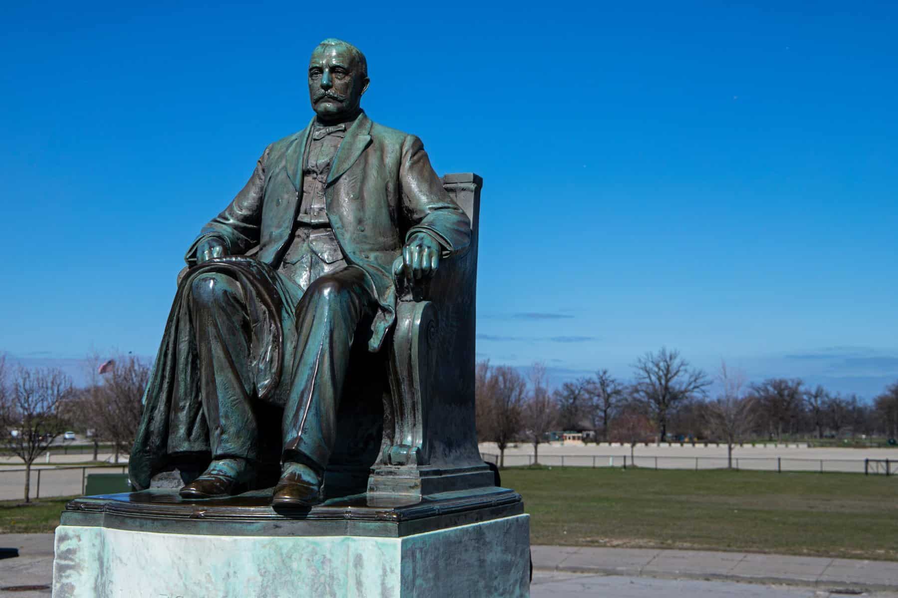 A staue of a man sitting in belle isle Detroit